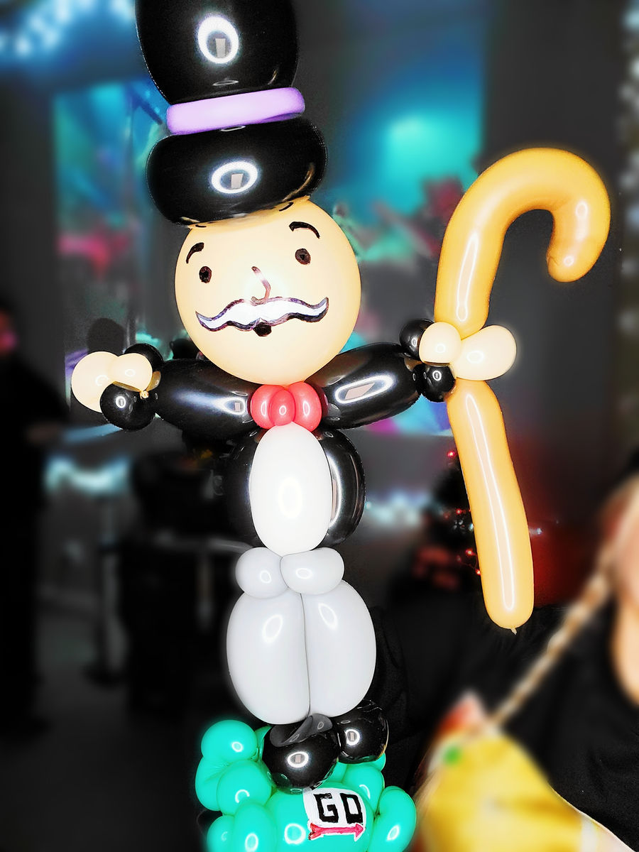 Balloon sculpture of a top-hatted board-game mascot holding a cane.