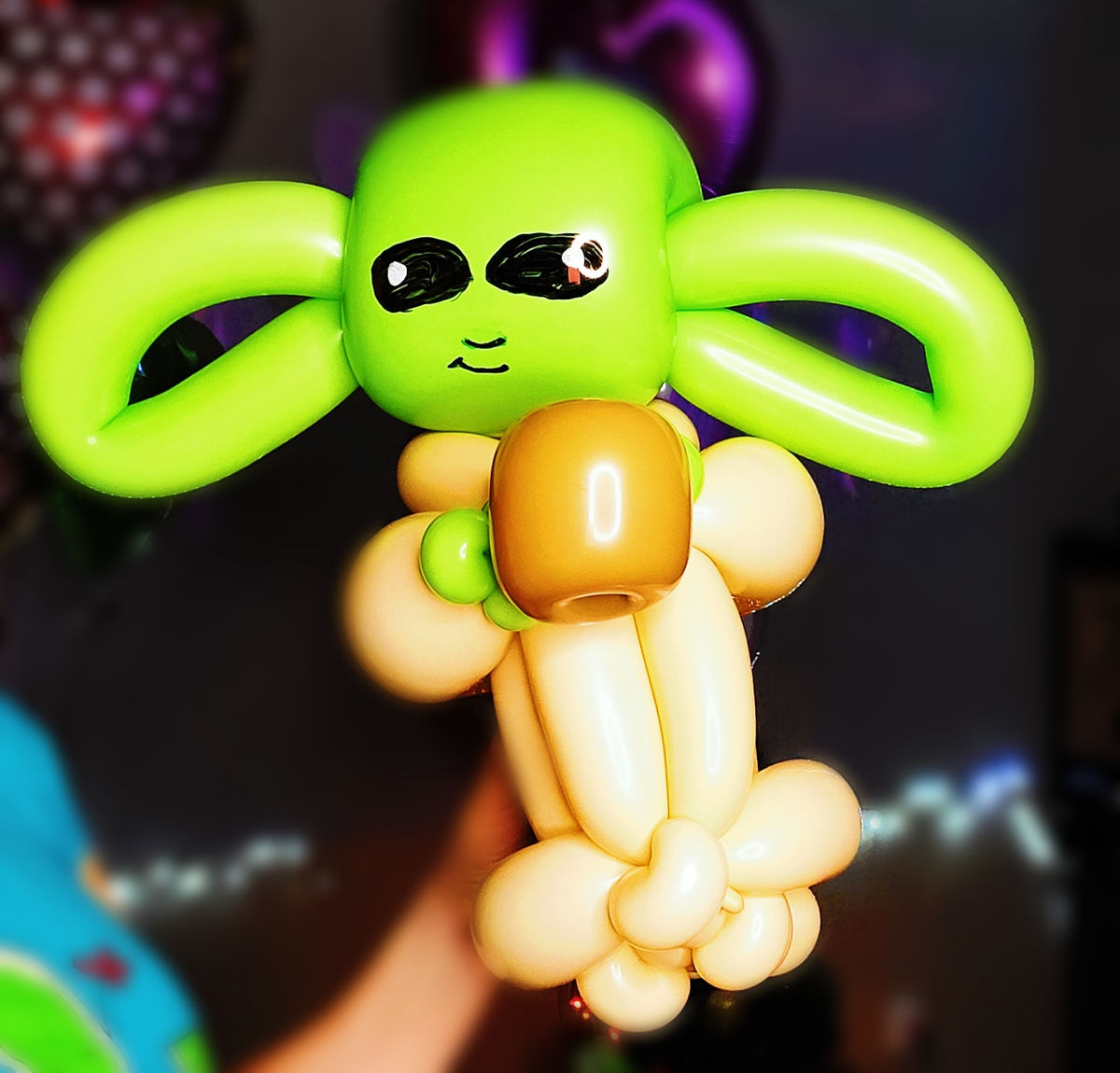 Detailed green balloon sculpture of a small big-eared science-fiction character.